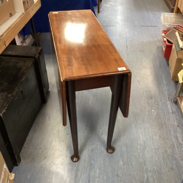 Antique mahogany gateleg table with drop leaf design.
