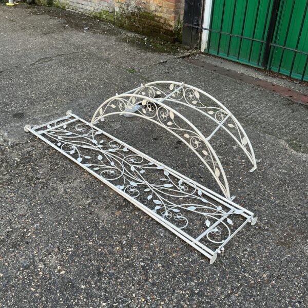Close-up of a decorative metal garden archway in a garden setting.