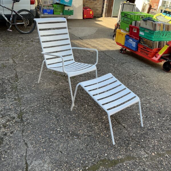 Vintage metal garden chair with integrated footrest for outdoor use.