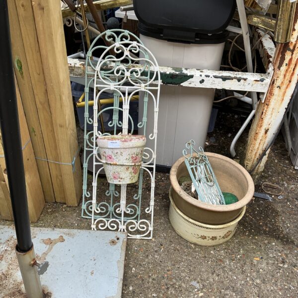 Vintage metal garden wall baskets with potted plants.