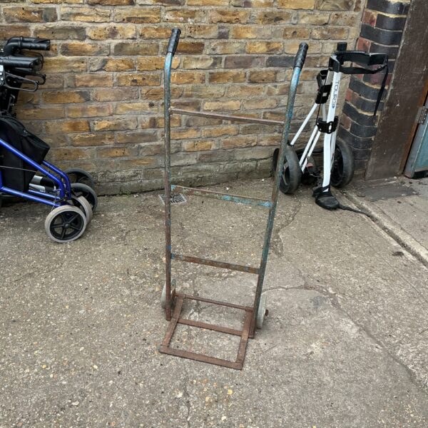 Small metal hand trolley with two wheels, side view.