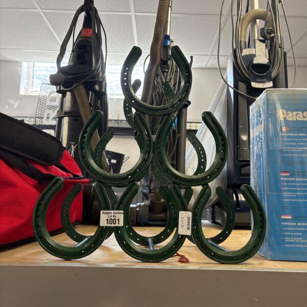 Rustic metal horseshoe wine rack for wine storage and display.