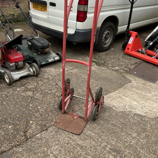 Metal stair climbing trolley with three wheels for lifting and moving.