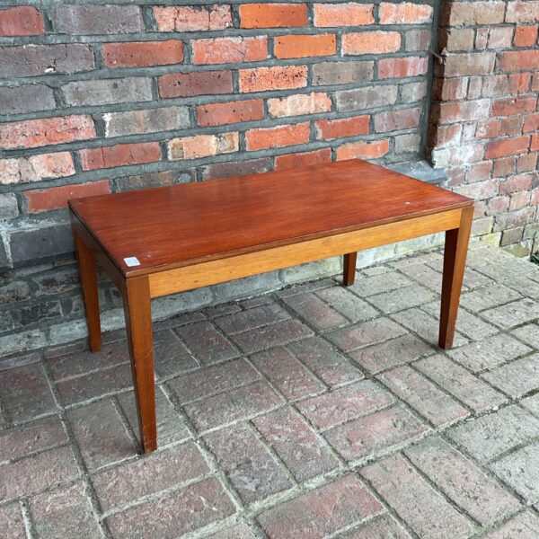 Vintage mid century coffee table against brick wall.