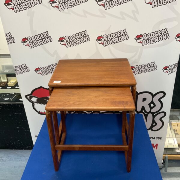 Vintage mid-century teak nesting tables in warm tones.