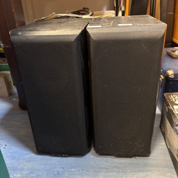 Pair of vintage Mission 701 bookshelf speakers in a home setting.