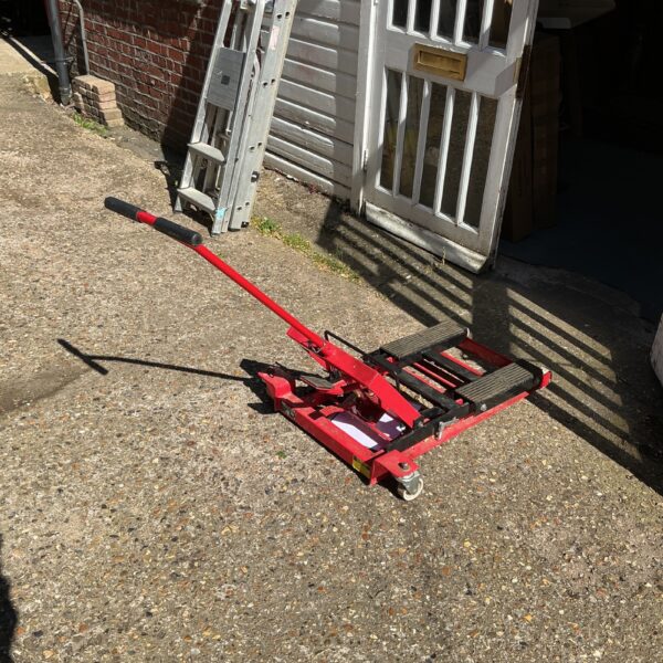 Red Clarke motorcycle lift in a garage setting.