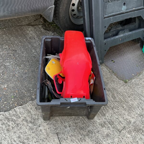 Vintage motorcycle scrambler parts in a plastic storage box.