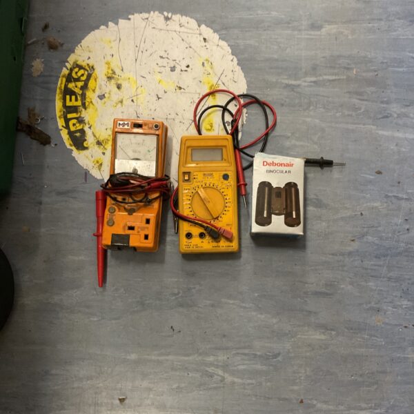 Digital multimeter and binoculars lot for electrical testing and viewing.