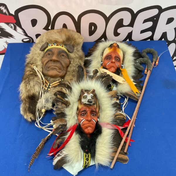Vintage Native American chief wall hangings with feathered headdresses.