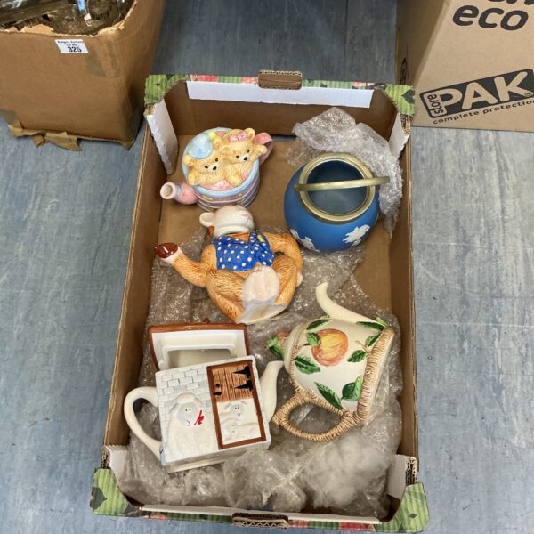 Collection of colourful novelty character teapots on display.