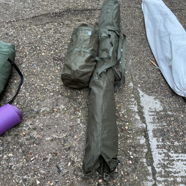 Used olive green fishing bivvy rolled up and ready for use.