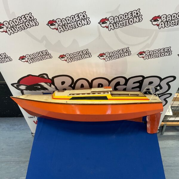 Orange wooden model boat on blue surface.