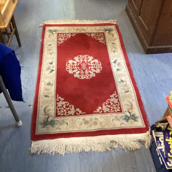 Detailed view of a patterned oriental red rug.