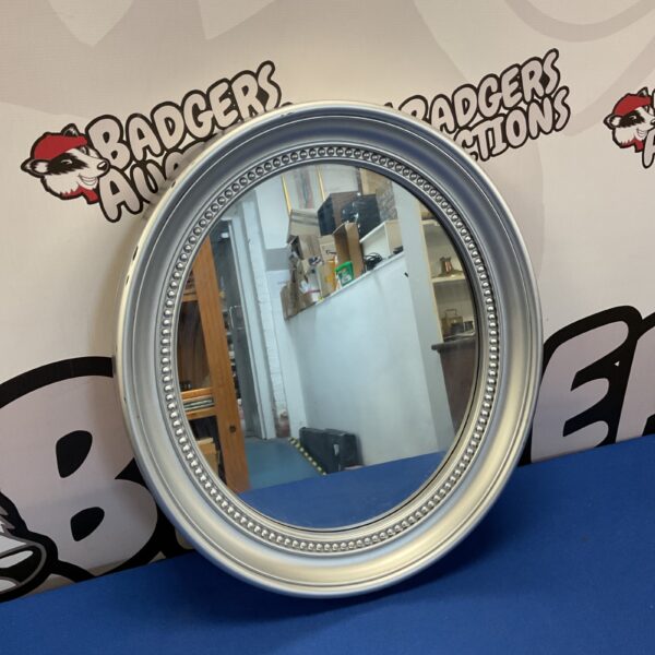 Silver plastic framed oval mirror for home decor.