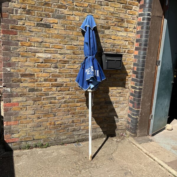 Vintage Peroni garden umbrella displayed outdoors, showing clear branding.