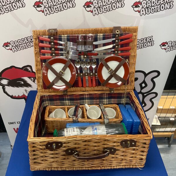 Wicker picnic basket set with dining accessories and blanket.