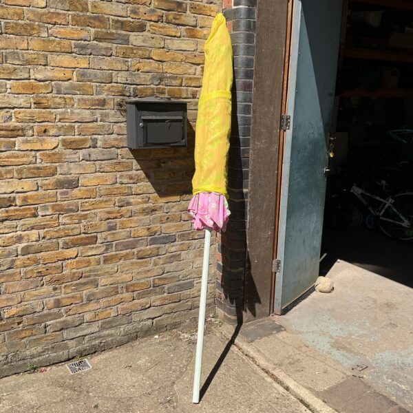 Large pink garden parasol providing outdoor shade.