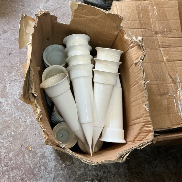 Lot of vintage plastic flower cases for display.