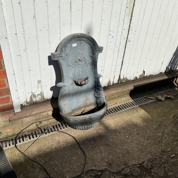 Decorative plastic wall mounted water feature for garden use.