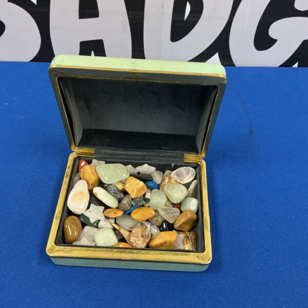 Polished stone collection in a wooden box, colourful gemstones.