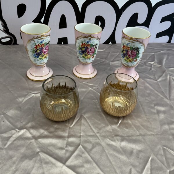 Vintage porcelain coupe goblets and tea light holders with floral designs.