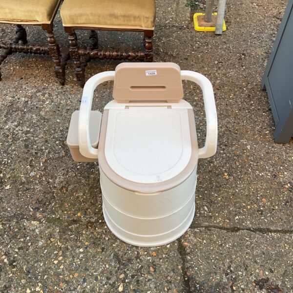 White portable commode toilet with armrests for mobility assistance.