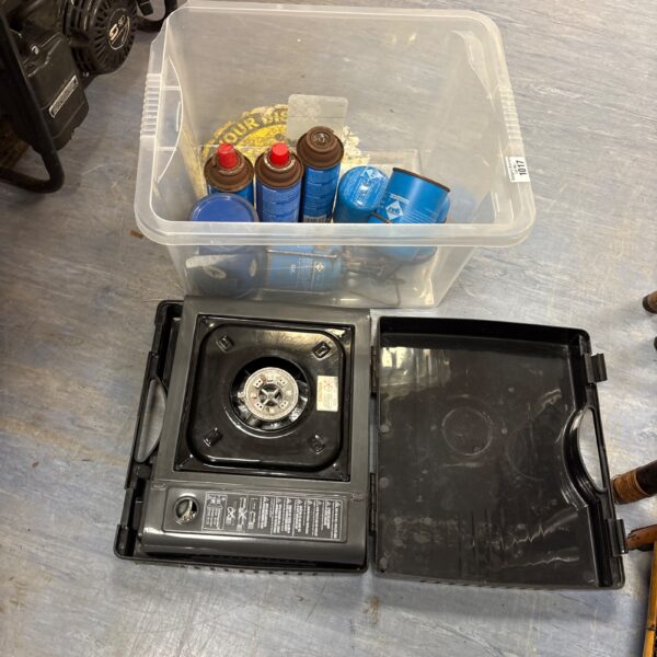 Used portable gas stove with gas canisters for outdoor cooking.