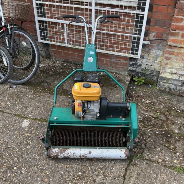 Vintage Protea petrol lawnmower in a garden setting.