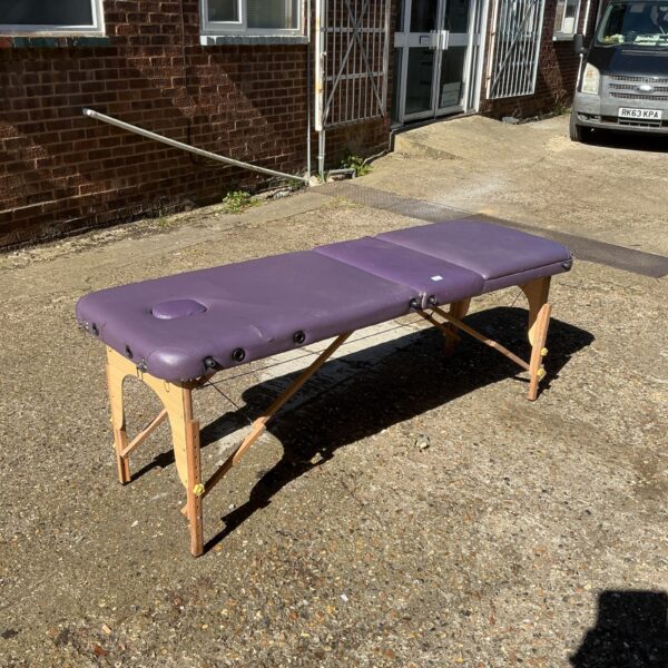Purple folding massage table for therapy and treatments.