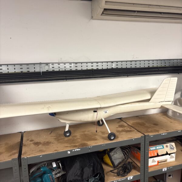 Vintage RC Cessna aeroplane model on a shelf.