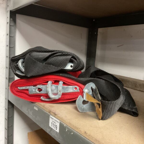 Red and black ratchet straps for securing cargo and vehicle loads.