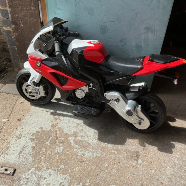 Red and black battery powered ride on motorcycle for kids.