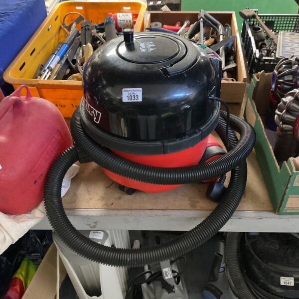 Red Numatic Henry vintage cylinder vacuum cleaner for domestic cleaning.