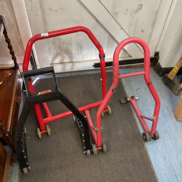 Red motorcycle lift stands for bike maintenance and repair.