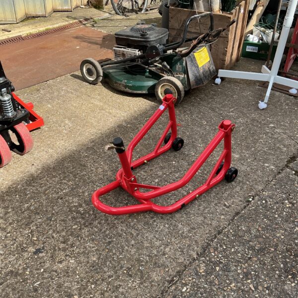 Red Warrior motorcycle stand for rear wheel lift and maintenance.