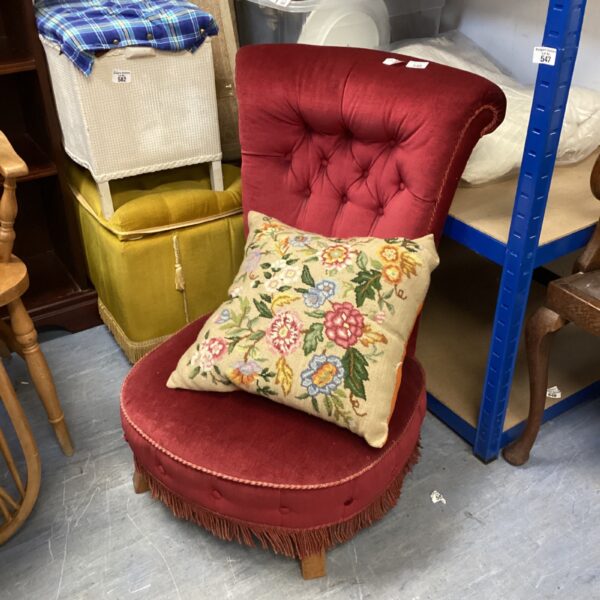 Red upholstered rattan conservatory chair with floral cushion.