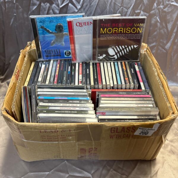 Lot of rock music CDs including Queen and Nirvana albums.
