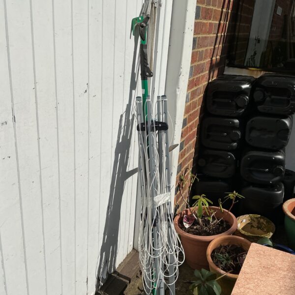 Metal rotary clothes line in a garden setting.