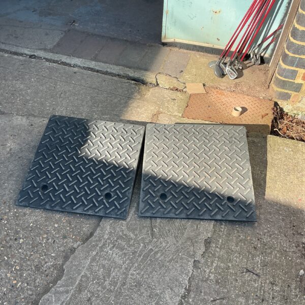 Pair of durable rubber access ramps for vehicles and driveways.