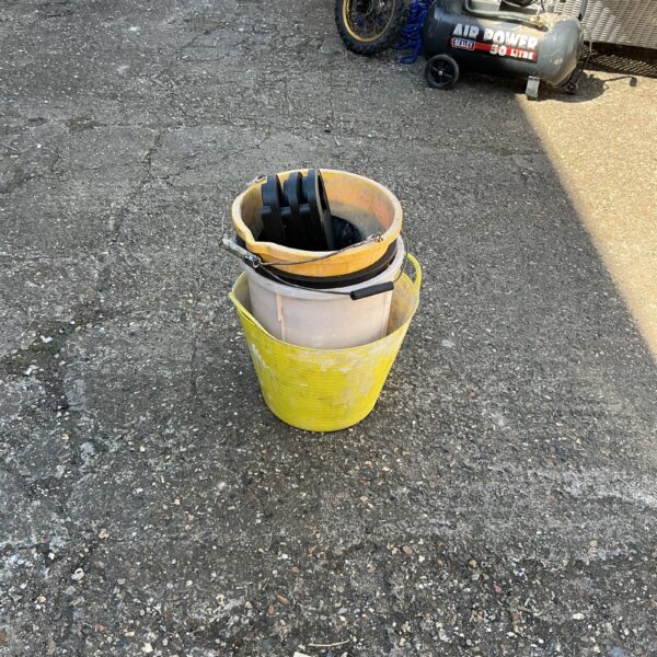 Grey rubble bucket and yellow plastic bucket for garden use.