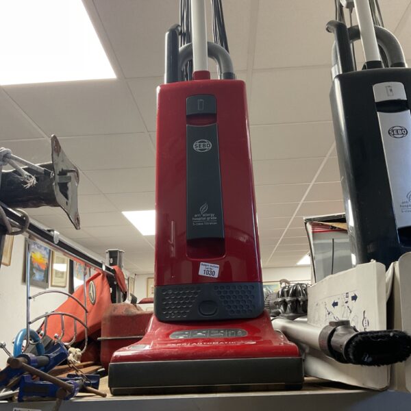 Red Sebo X4 upright vacuum cleaner for domestic cleaning.