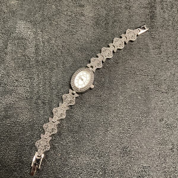 Close-up of a vintage Sekonda markasite watch on a dark surface.