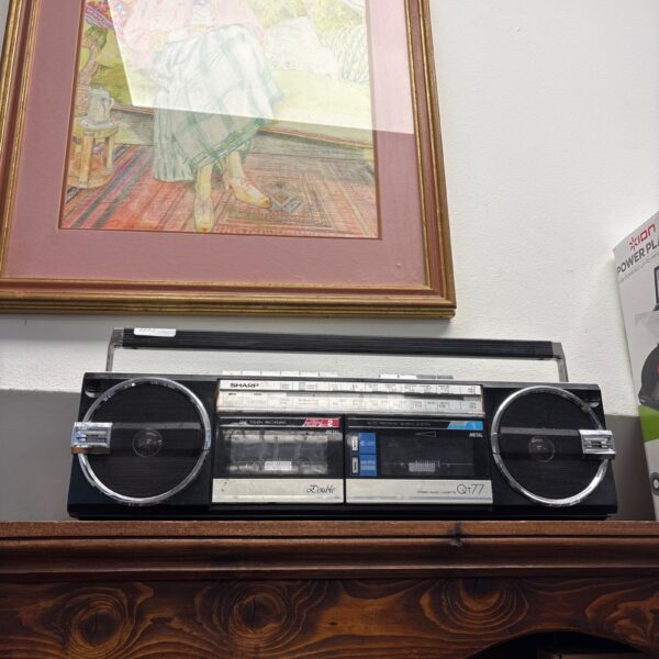 Vintage Sharp QT-77Z radiocassette recorder with artwork background.