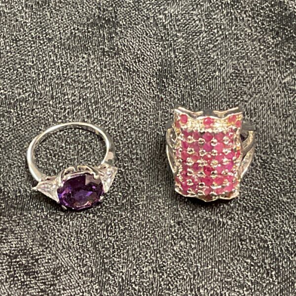 Silver ring with a central amethyst stone and white accents.
