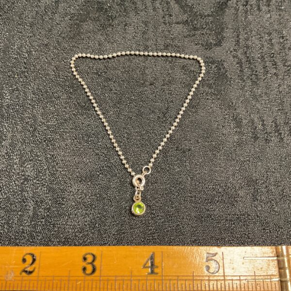 Delicate 925 silver ankle bracelet with a green stone pendant.