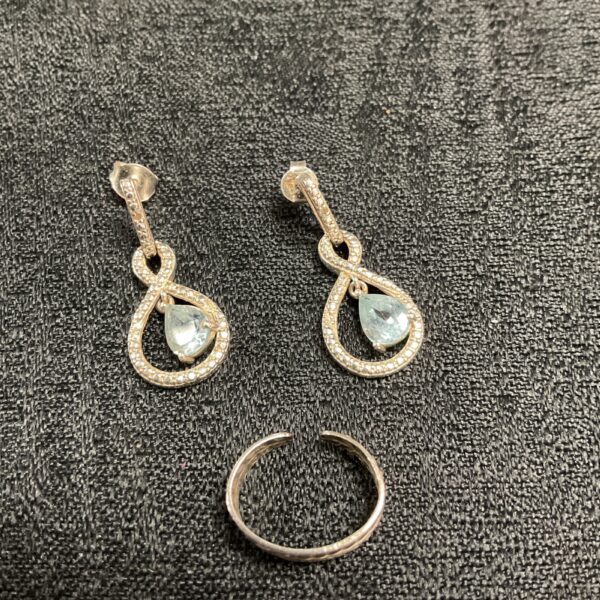 Silver drop earrings and toe ring set with pale blue stones.