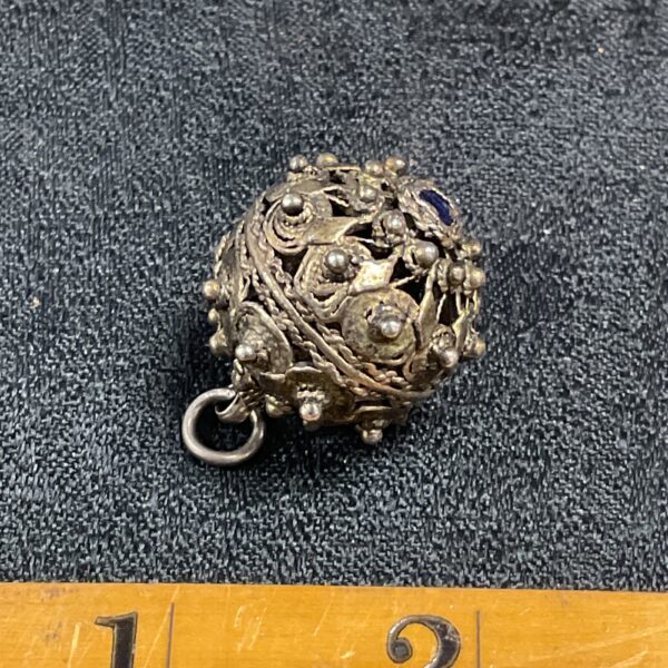 Antique silver filigree pendant with blue stone detail.