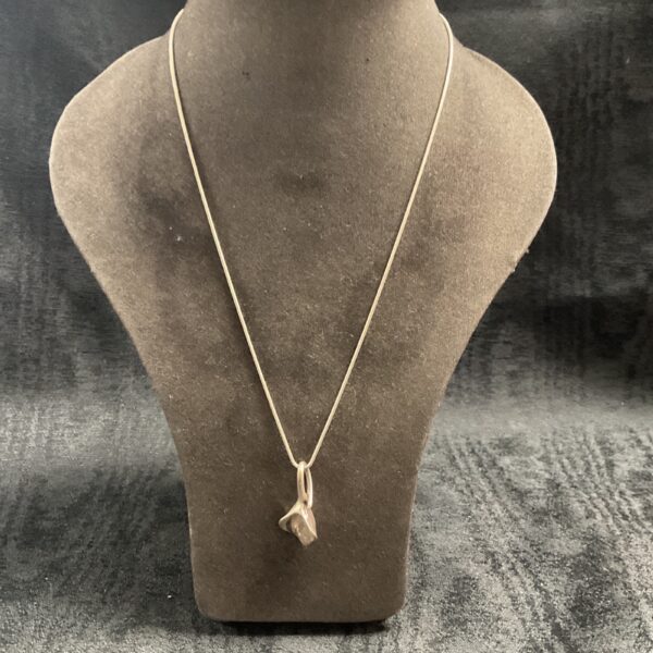 Delicate silver flower pendant on a snake chain necklace.