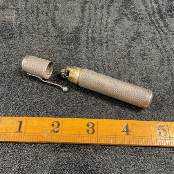 Antique silver petrol lighter with textured body.